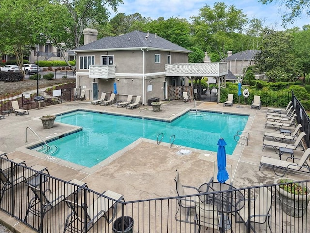 pool with a patio and fence