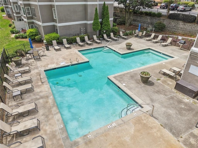 community pool featuring a patio and fence