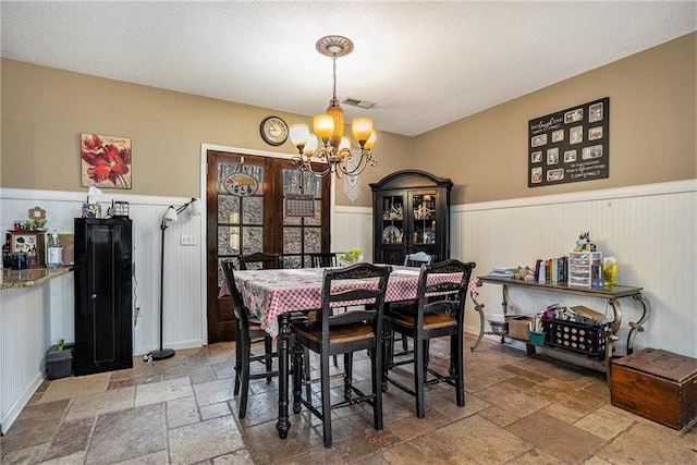 dining space featuring a textured ceiling and a chandelier