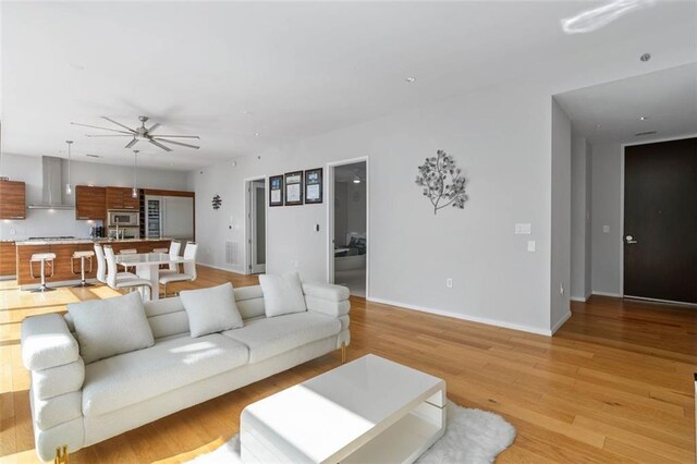 living room featuring ceiling fan and light hardwood / wood-style flooring