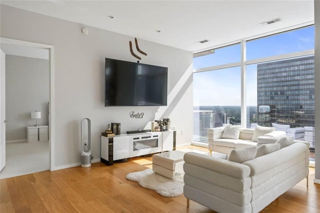 living room with light hardwood / wood-style flooring and a wall of windows