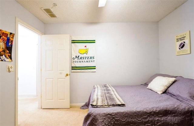 bedroom featuring a textured ceiling, ceiling fan, and light carpet