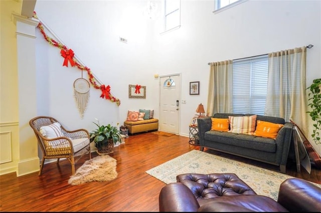 living room with hardwood / wood-style floors and a high ceiling