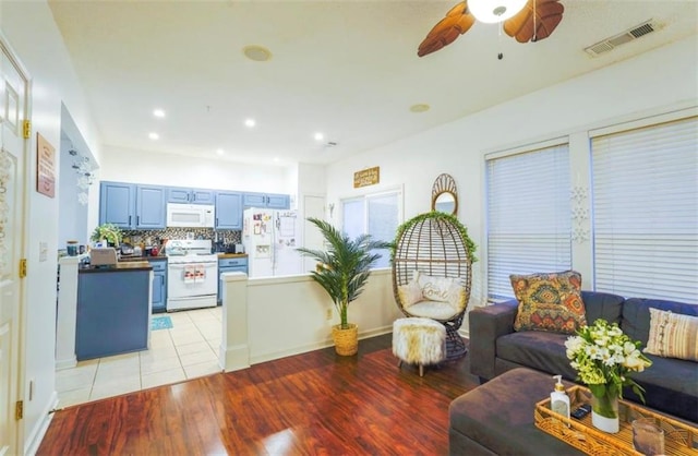 living room with ceiling fan and light hardwood / wood-style flooring