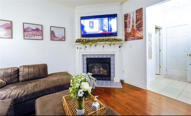 living room with a tiled fireplace and hardwood / wood-style floors