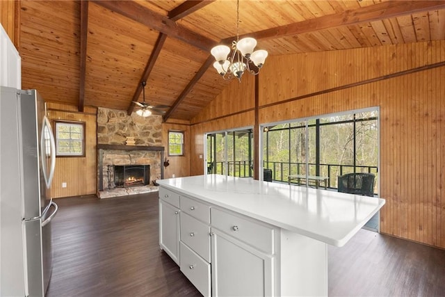 kitchen featuring appliances with stainless steel finishes, wooden ceiling, wooden walls, dark wood-style floors, and vaulted ceiling with beams