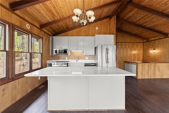 interior space with ceiling fan with notable chandelier, beam ceiling, wooden ceiling, wooden walls, and dark wood-style floors