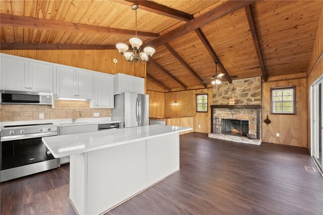kitchen featuring freestanding refrigerator, wooden ceiling, wooden walls, and dark wood-style floors