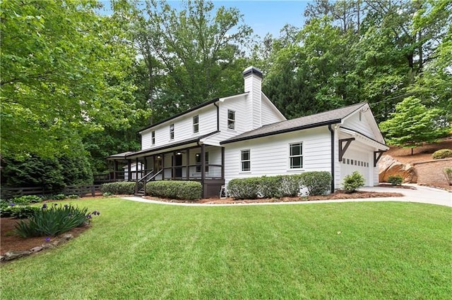 back of property featuring a garage, a yard, and covered porch