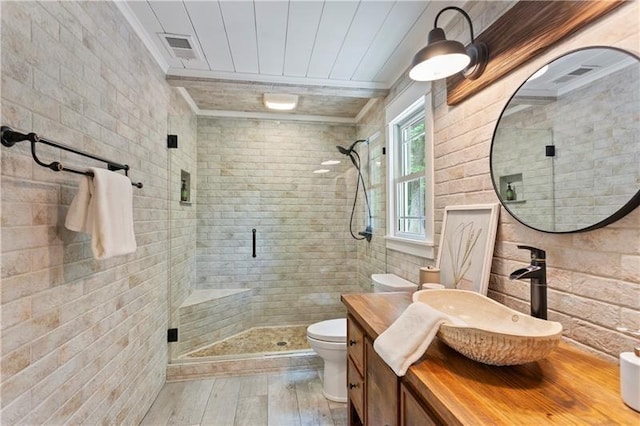 bathroom with hardwood / wood-style floors, vanity, toilet, a shower with door, and crown molding