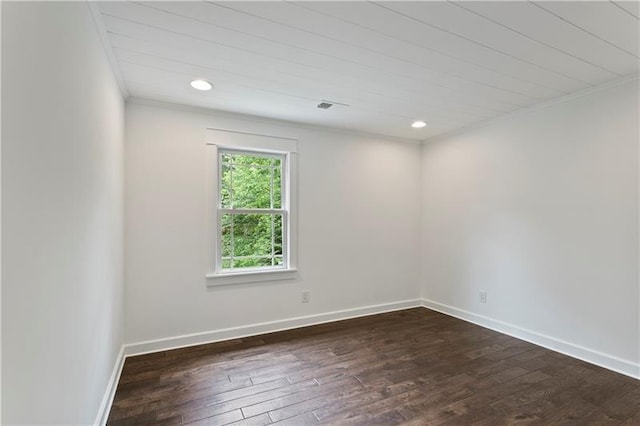 spare room with ornamental molding and dark hardwood / wood-style floors