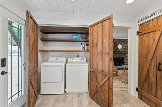 washroom featuring wood ceiling, light wood-type flooring, ornamental molding, a fireplace, and washer and clothes dryer