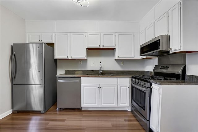 kitchen with sink, dark hardwood / wood-style floors, white cabinets, and appliances with stainless steel finishes