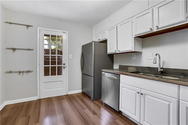 kitchen featuring white cabinetry, sink, stainless steel appliances, and dark hardwood / wood-style floors