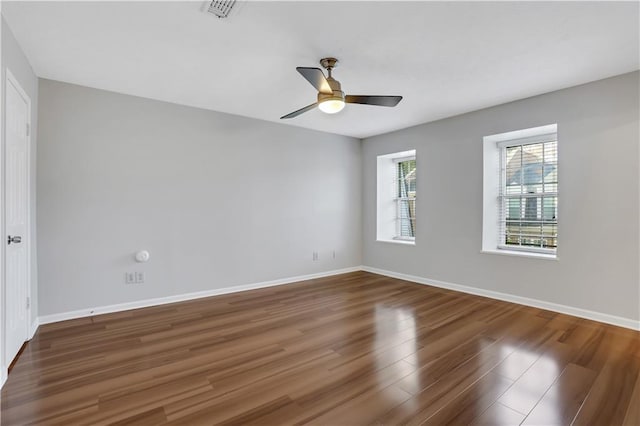 empty room with ceiling fan and dark hardwood / wood-style flooring