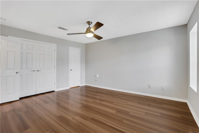 unfurnished bedroom featuring dark hardwood / wood-style flooring, a closet, and ceiling fan