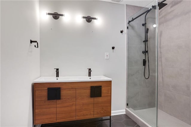 bathroom with tile patterned flooring, vanity, and a tile shower