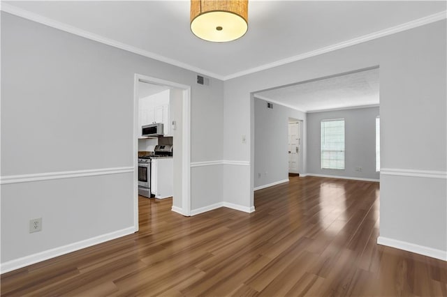 empty room with hardwood / wood-style flooring and crown molding