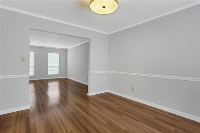 empty room with crown molding and wood-type flooring