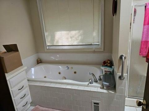 bathroom featuring separate shower and tub