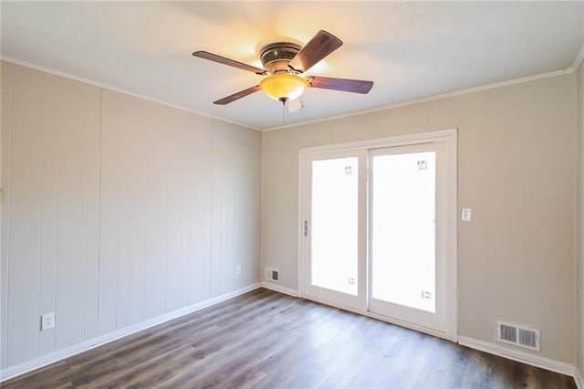 spare room with ceiling fan, visible vents, dark wood-style floors, and ornamental molding