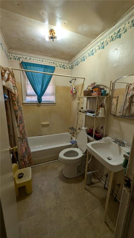 bathroom featuring shower / bath combo and toilet