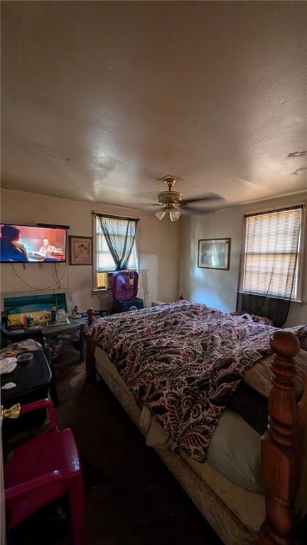 bedroom with a fireplace and ceiling fan