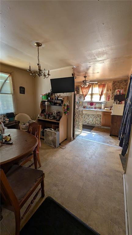 dining area with ceiling fan with notable chandelier