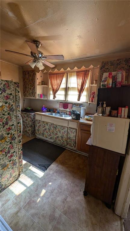 interior space featuring white fridge, ceiling fan, and sink