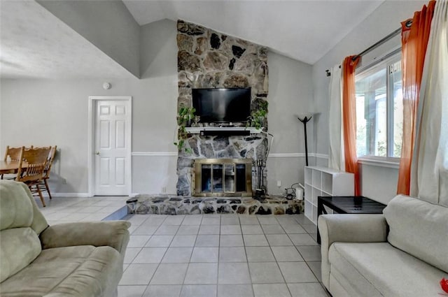 living room with lofted ceiling, light tile patterned flooring, and a stone fireplace