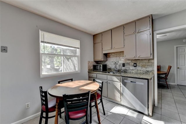 kitchen featuring sink, appliances with stainless steel finishes, backsplash, and light tile patterned floors