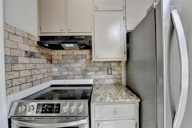 kitchen featuring appliances with stainless steel finishes, light stone counters, white cabinetry, and tasteful backsplash