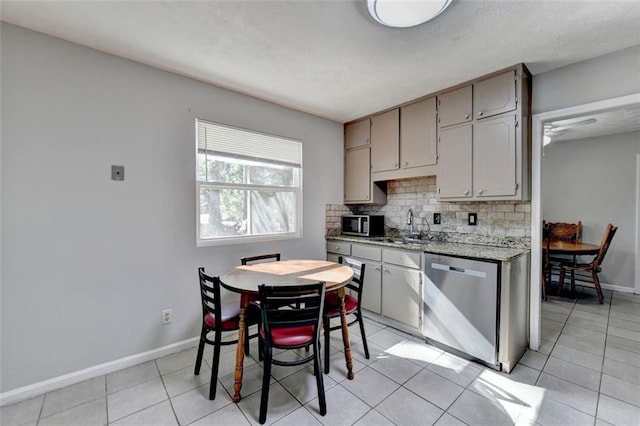 kitchen featuring gray cabinetry, stainless steel appliances, tasteful backsplash, and light tile patterned flooring