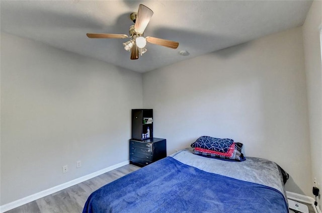 bedroom with light hardwood / wood-style floors and ceiling fan