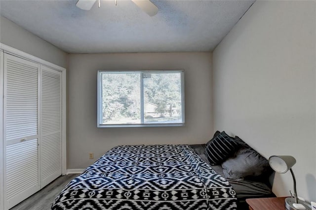 bedroom featuring light hardwood / wood-style floors, a closet, a textured ceiling, and ceiling fan