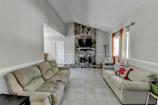 tiled living room featuring lofted ceiling and a stone fireplace