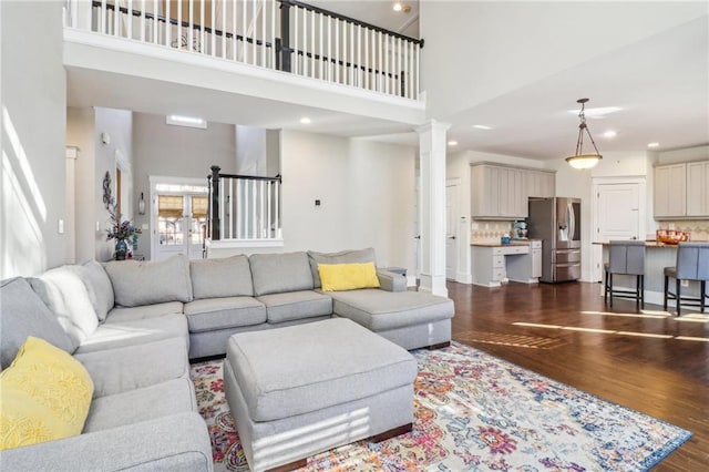 living room featuring dark hardwood / wood-style flooring and a towering ceiling