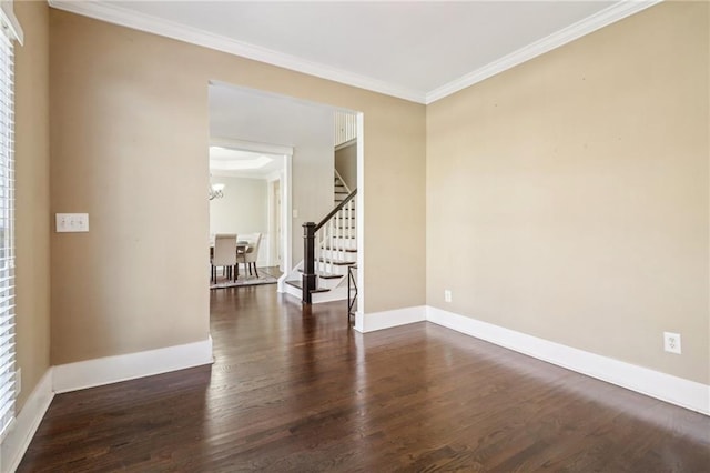 spare room featuring a chandelier, dark hardwood / wood-style floors, and ornamental molding