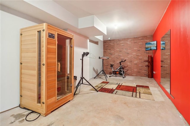 workout room featuring brick wall