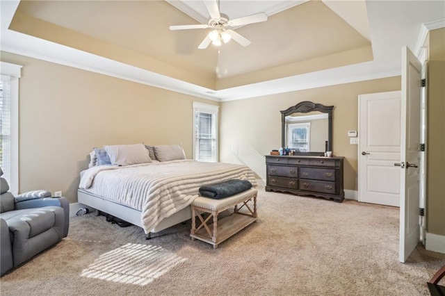 bedroom featuring ceiling fan, a raised ceiling, and light colored carpet