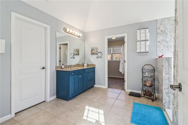 bathroom featuring tile patterned flooring, vanity, and vaulted ceiling