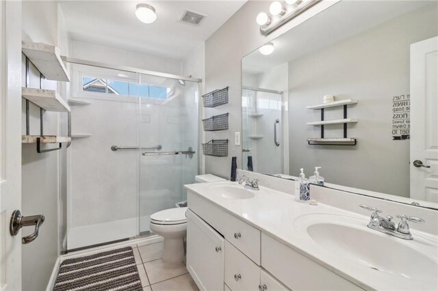 bathroom featuring toilet, tile patterned flooring, vanity, and walk in shower