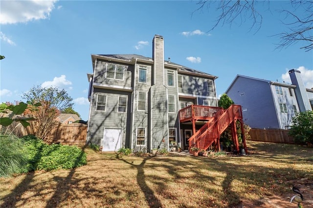 back of house featuring a lawn and a deck