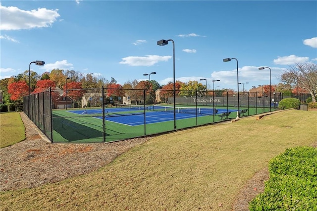 view of tennis court with a yard