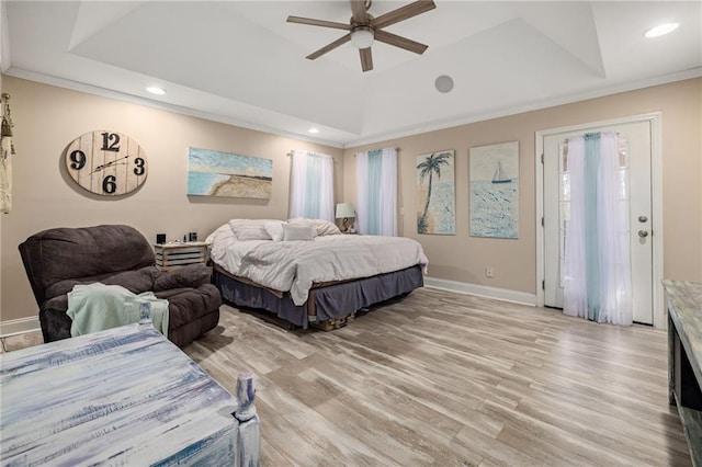 bedroom with a tray ceiling, baseboards, light wood-style floors, ornamental molding, and recessed lighting