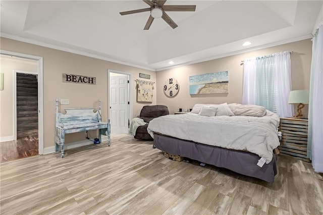 bedroom with baseboards, a tray ceiling, and wood finished floors