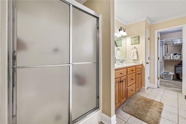full bath with tile patterned flooring, vanity, ornamental molding, baseboards, and a stall shower