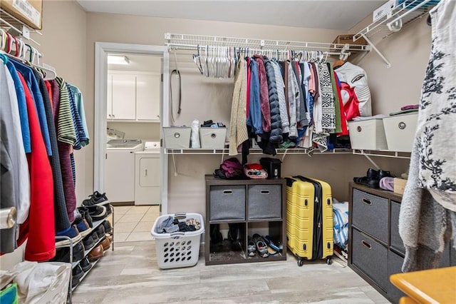 walk in closet with independent washer and dryer and wood finished floors