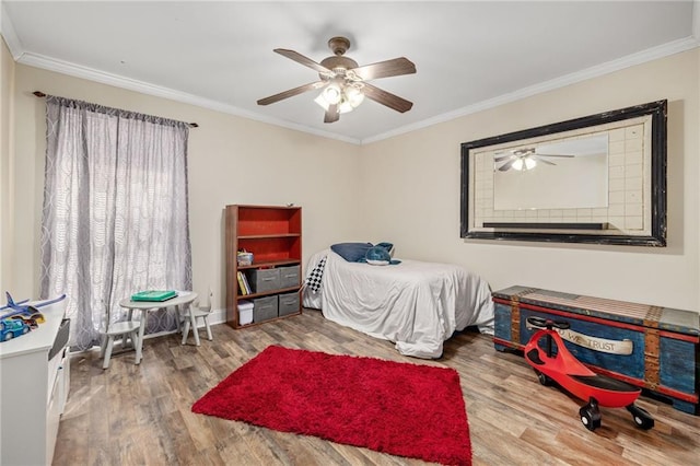 bedroom featuring ornamental molding, wood finished floors, and a ceiling fan