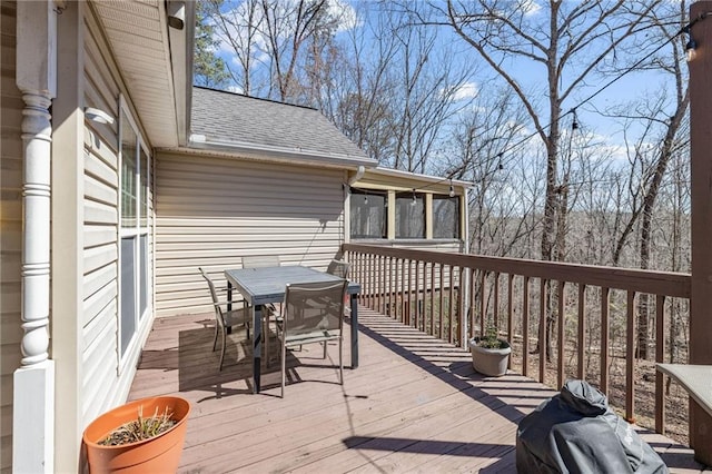 deck with a grill and outdoor dining area